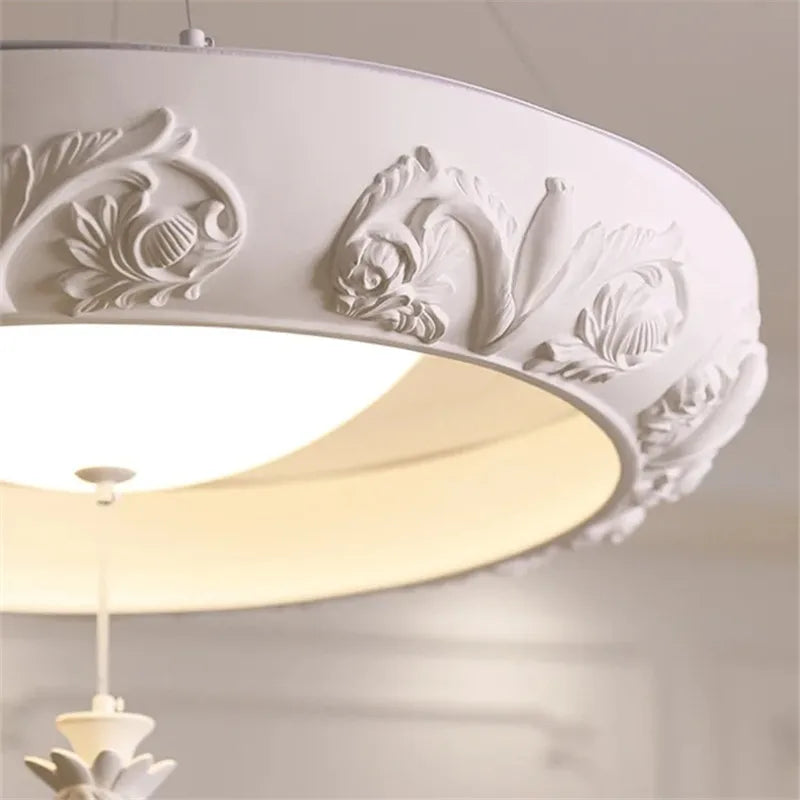 Decorative ceiling light fixture with floral patterns on a plain background