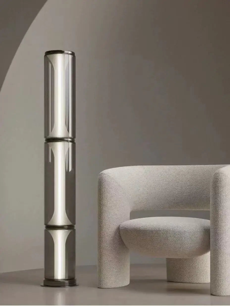 Modern chair with a cylindrical metallic object against a neutral background