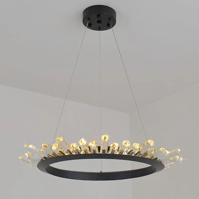 Modern chandelier with black frame and gold accents on a gray background