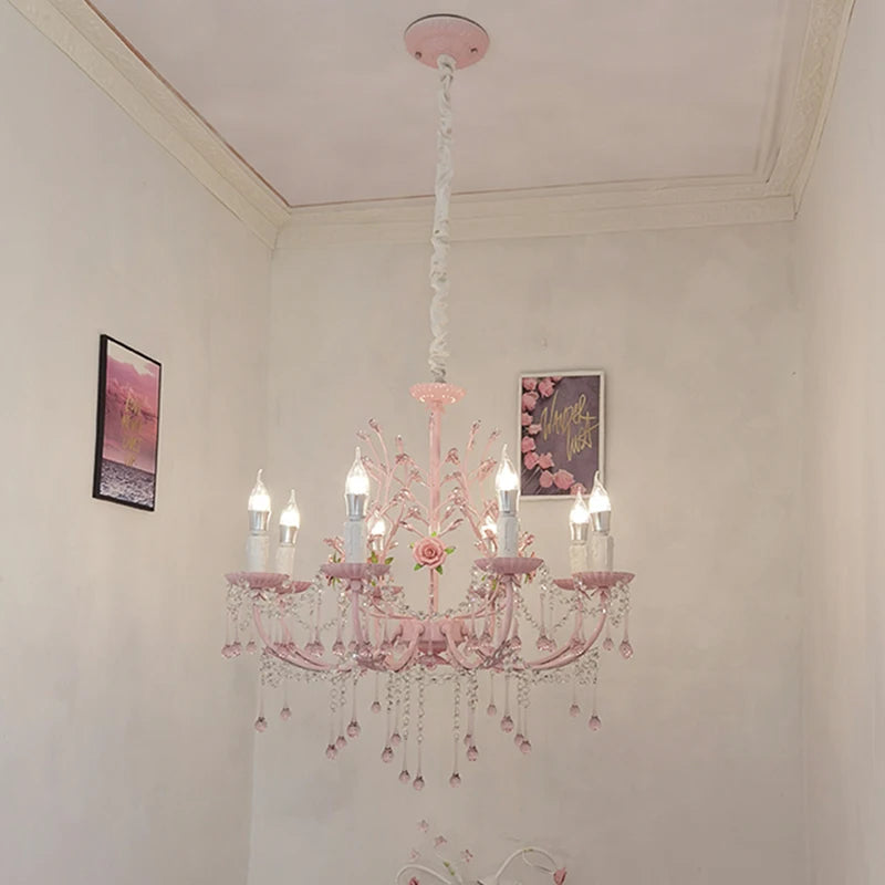 The pink floral crystal chandelier hanging from a ceiling in a room, with wall art visible in the background.