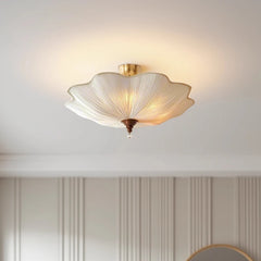 Interior view of a room featuring a white fabric lotus-shaped semi-flush ceiling light, casting a warm glow.