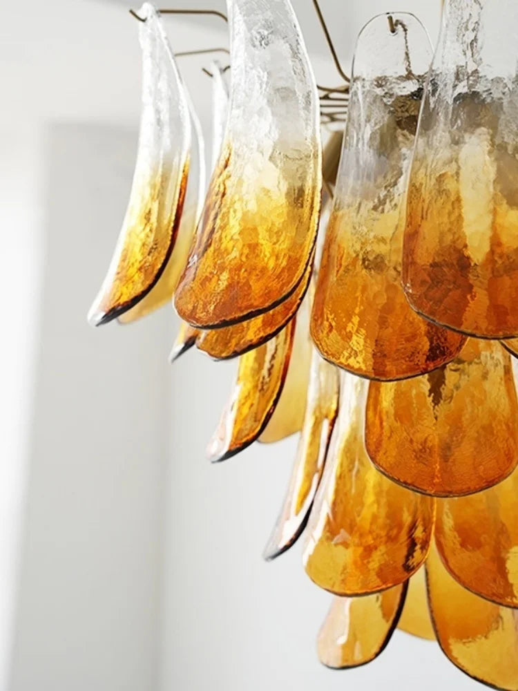 Ornate glass chandelier with amber-colored glass elements on a white background