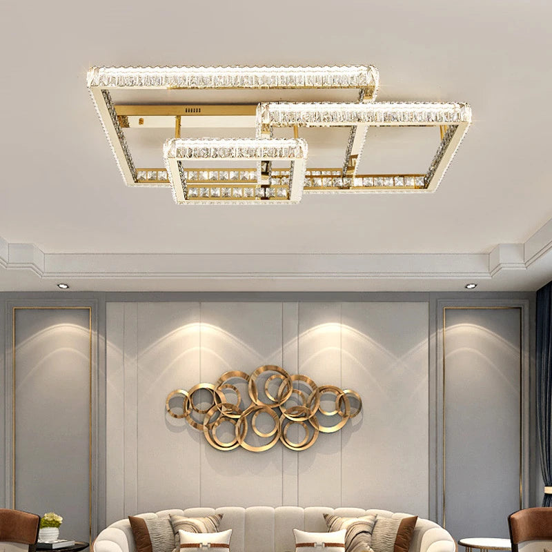 Gold geometric flush mount ceiling light with multiple rectangular frames adorned with clear crystals, installed in a living room above a sofa and art.