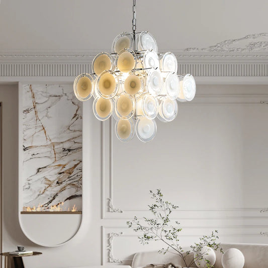 A modern chandelier with multiple white and yellow glass petals cascading downwards, mounted on a chain from a white ceiling.