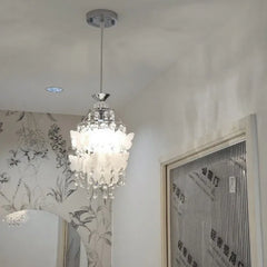 A chrome pendant light with butterfly accents and crystals hanging from a white ceiling.