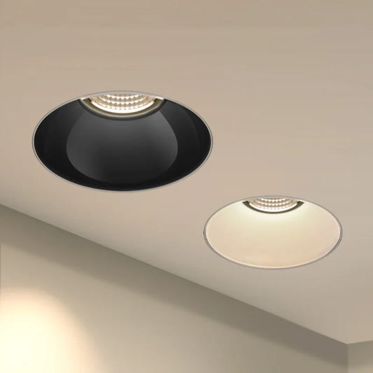 Two recessed ceiling spotlights, one with a black interior and one with a white interior, installed on a white ceiling.