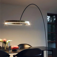Modern floor lamp with a curved design in a room setting.