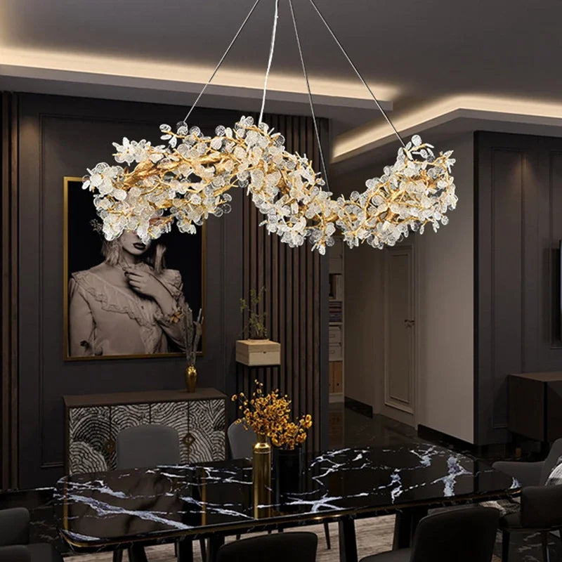 Luxury chandelier hanging in a modern dining room with marble table and decor.