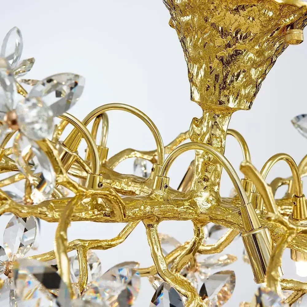 Close-up of a gold chandelier with crystal elements on a white background