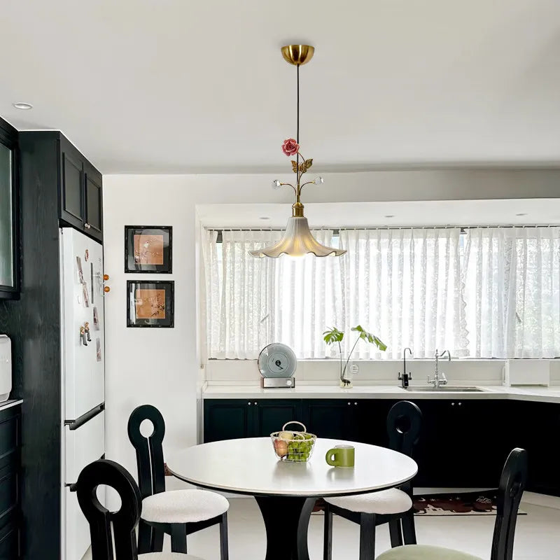 Kitchen area with a gold floral rose bud ceramic pendant light above a round table with chairs
