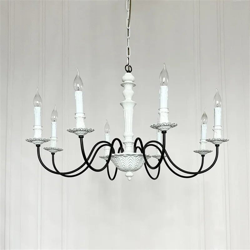 Black chandelier with white candles on a light gray background