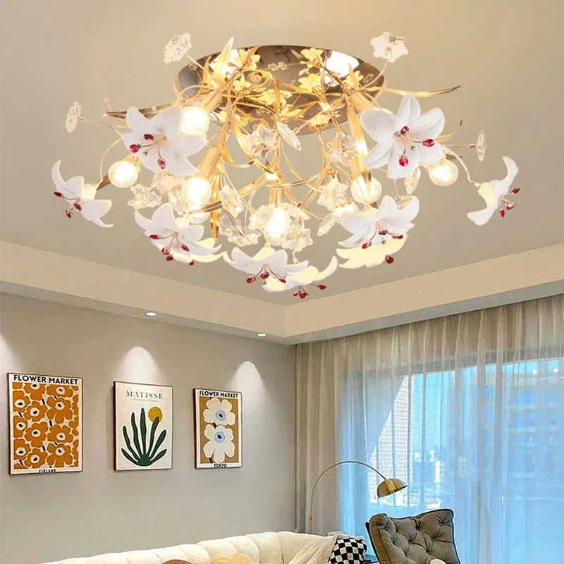 Gold floral chandelier with white petals and crystal accents, flush mounted on a ceiling