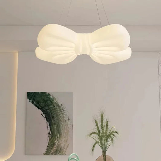 White butterfly knot shaped pendant light hanging in a dining area