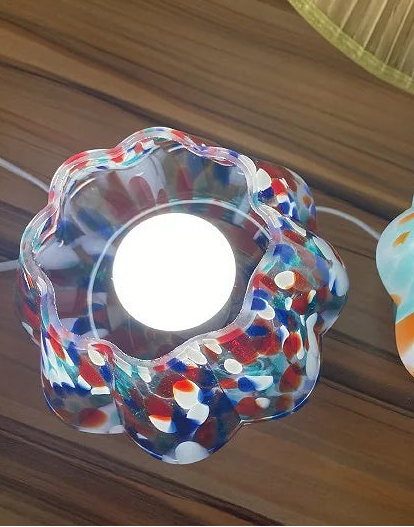 Two colorful glass lampshades with a blurred background