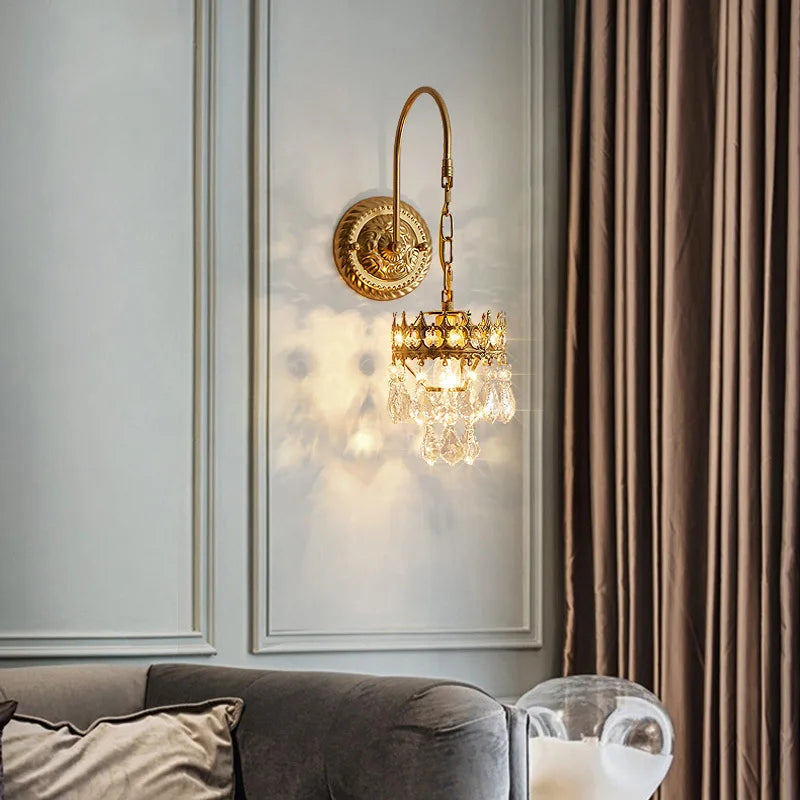 Gold wall sconce with crystal details in a living room setting.