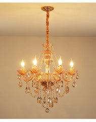 Gold crystal chandelier with cascading teardrop and faceted crystal accents, featuring candle-style bulbs and a polished gold finish.