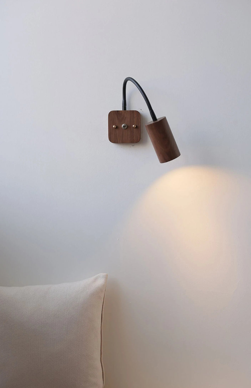 Wooden wall sconce on a white wall with a soft glow