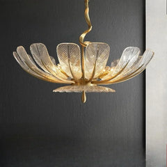 Side view of a gold leaf floral chandelier featuring clear glass petals and a twisted central stem.