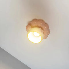 Underside view of the illuminated pink ceramic coffee cup ceiling light, revealing the opening for light.