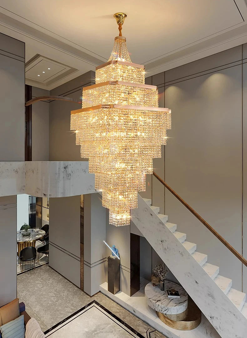 Luxurious chandelier hanging in a modern interior setting with staircase and decor.