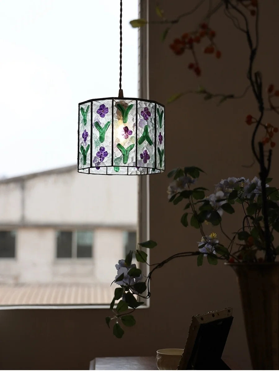 Decorative pendant light with floral design hanging in a room.