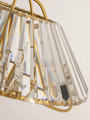 A gold crystal faceted pendant light with a wide, flared shade, showcasing prismatic light effects.