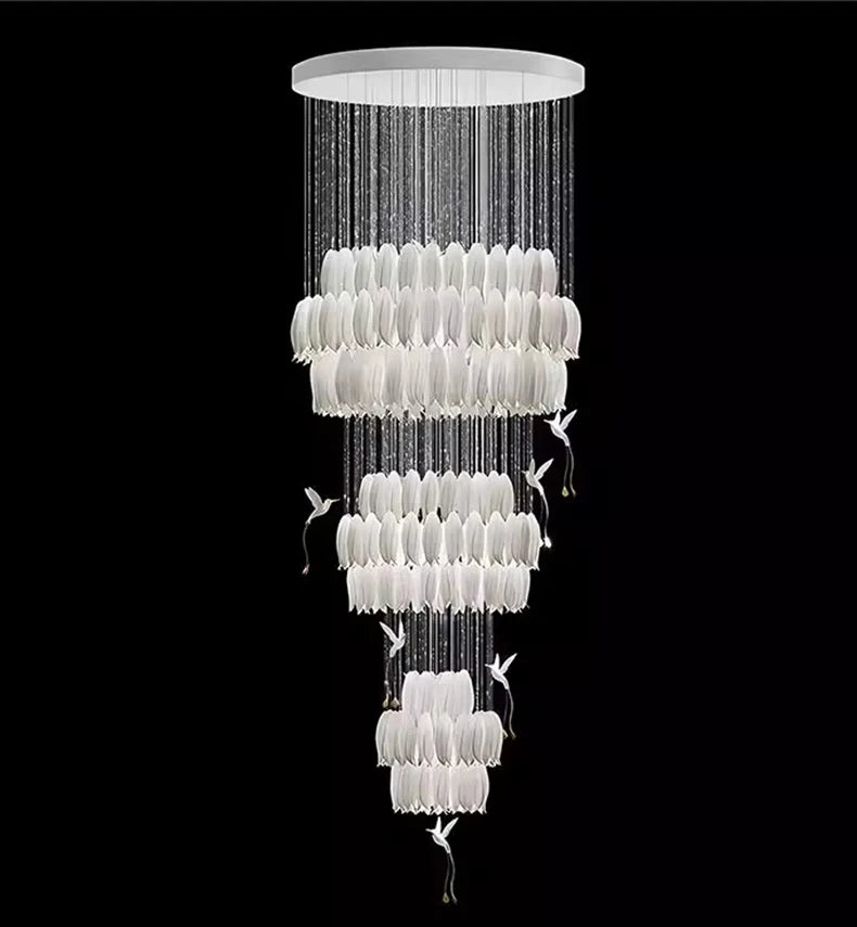 Chandelier with multiple tiers of white lampshades on a black background