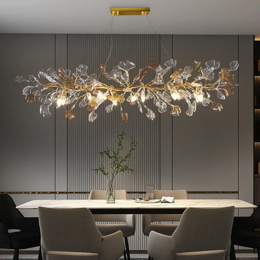 Gold leaf crystal chandelier with a branch-like design hanging over a dining table.
