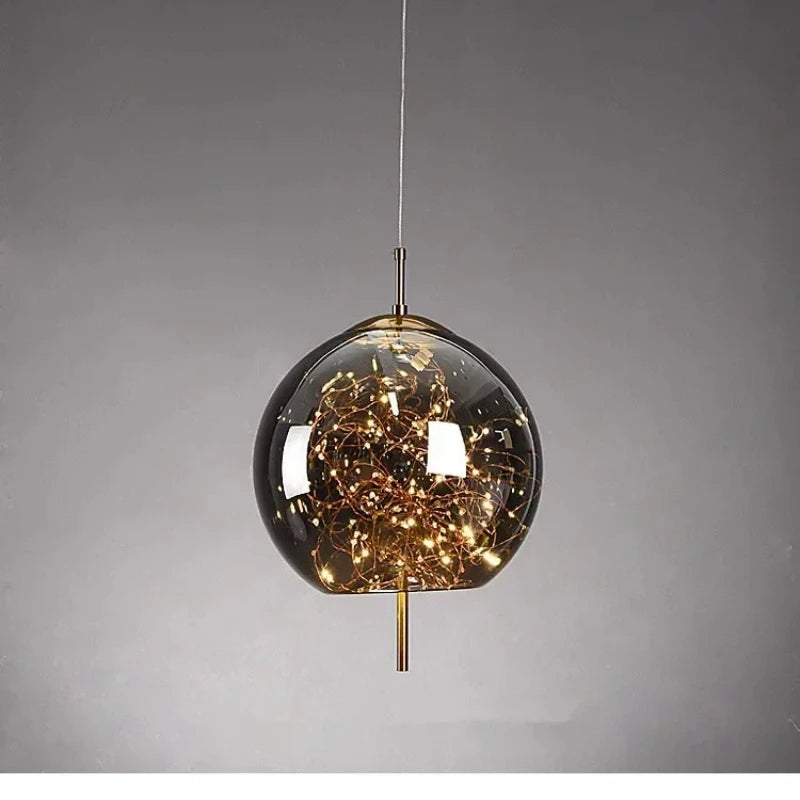 A single spherical glass pendant light filled with warm LED lights and gold accents, presented against a neutral background.