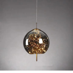 A single spherical glass pendant light filled with warm LED lights and gold accents, presented against a neutral background.