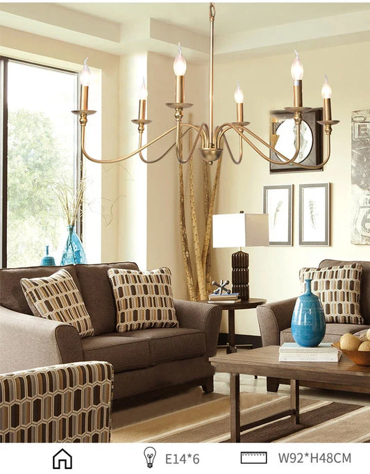 Gold candelabra-style chandelier with curved arms, illuminating a living room space.