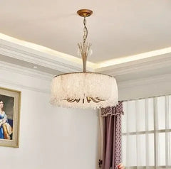 Side view of the gold crystal waterfall pendant light against a white ceiling and wall.