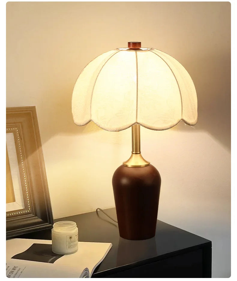 Decorative table lamp with a brown base and white shade on a dark surface.