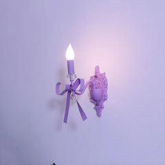 A single purple bow candle-style wall sconce with decorative accents, illuminated against a plain purple wall.