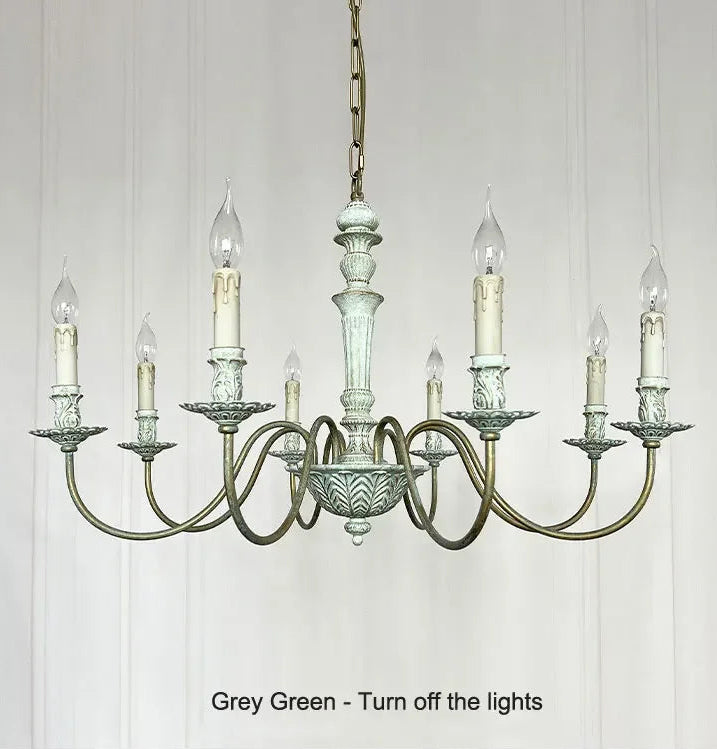 Vintage-style chandelier with glass shades on a white paneled wall.
