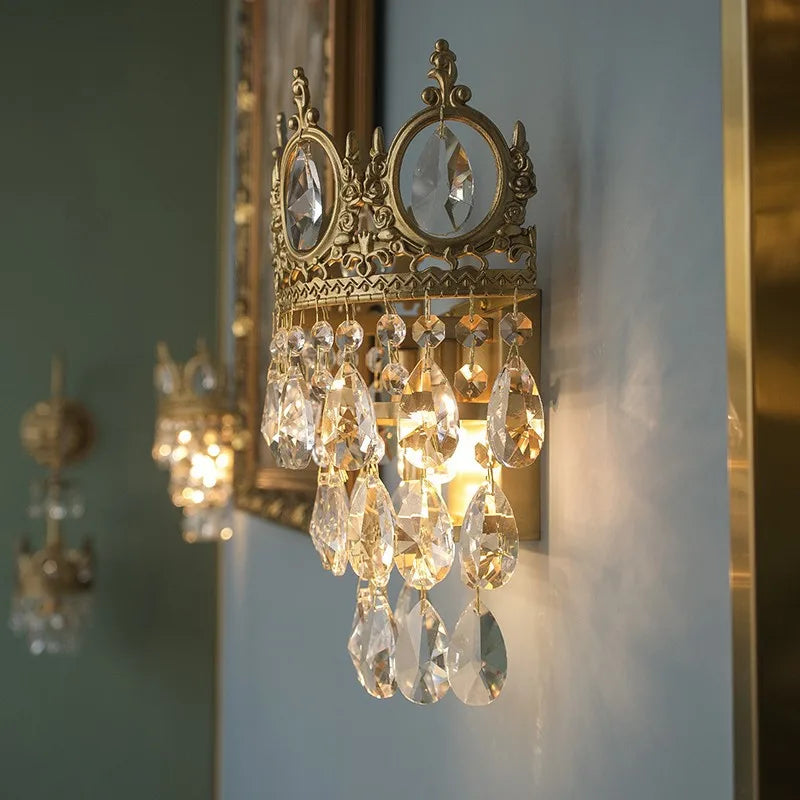 Decorative wall sconce with crystal accents on a light blue wall.