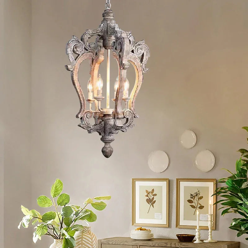 Decorative chandelier hanging in a room with wall art and plants.