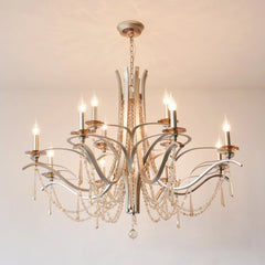 Close-up of the brushed gold metalwork and clear teardrop crystals on the tiered chandelier.