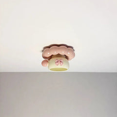 Frontal view of the pink ceramic coffee cup ceiling light mounted on a white ceiling, highlighting its whimsical design.