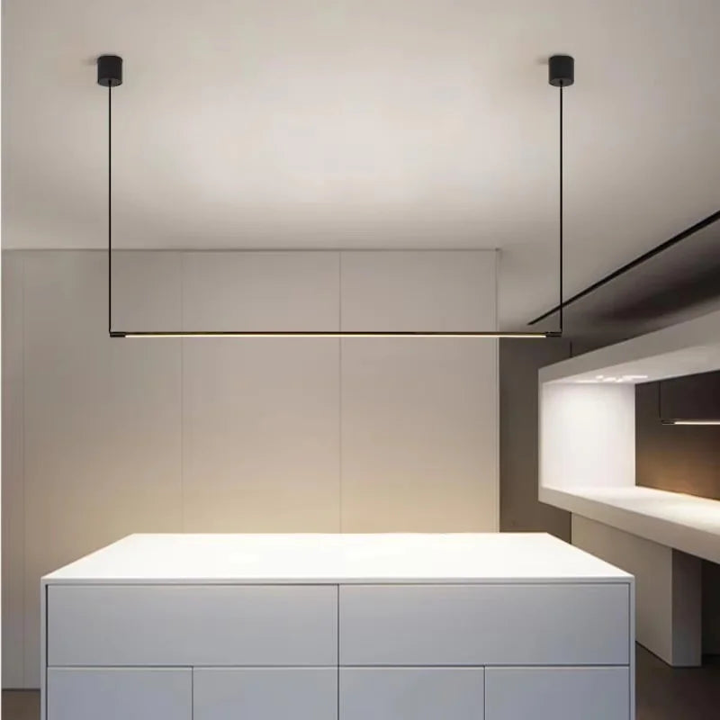 Black minimalist linear pendant light suspended over a kitchen island