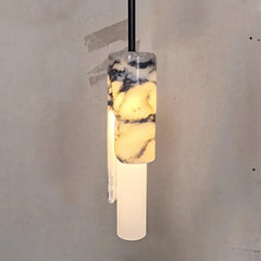 A single marble and wood pendant light with a frosted glass lower section, shown against a textured concrete wall.