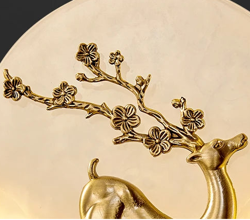 Decorative wall light with deer and floral design on a black background