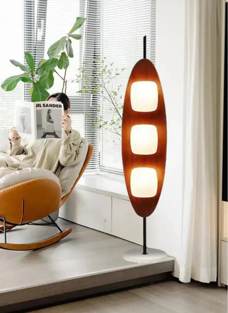 Modern interior design with a hanging lamp, rocking chair, and plant.