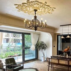 An open-concept living and dining area showcasing a large sliding glass door and a grand bronze crystal chandelier suspended above the dining table.
