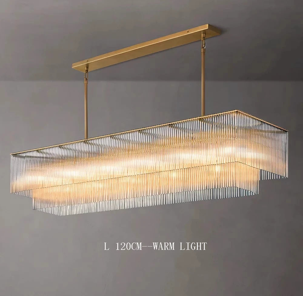 Rectangular pendant light with gold frame and warm light on a gray background