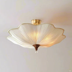 A white fabric lotus-shaped semi-flush ceiling light with polished gold hardware, viewed from a slightly lower angle.
