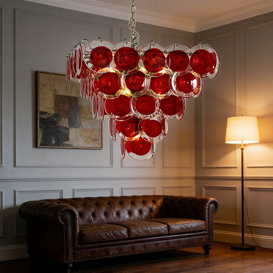 A close-up view of the red glass discs on a tiered chandelier, illuminated from within.