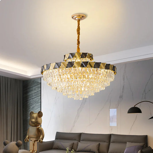 Side view of a gold tiered crystal chandelier with crystal droplets illuminated in a living room.