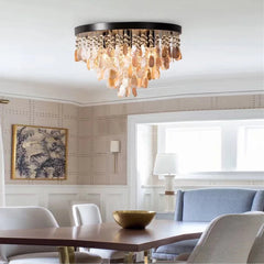 A gold and shell semi-flush mount ceiling light with multiple tiers of teardrop shapes hanging from a circular base, illuminating a dining area.