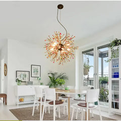 A colorful pearl and iron dandelion starburst pendant light illuminating a bright dining room with white furniture.